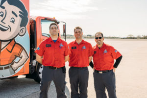 3 master plumbers in front of their truck