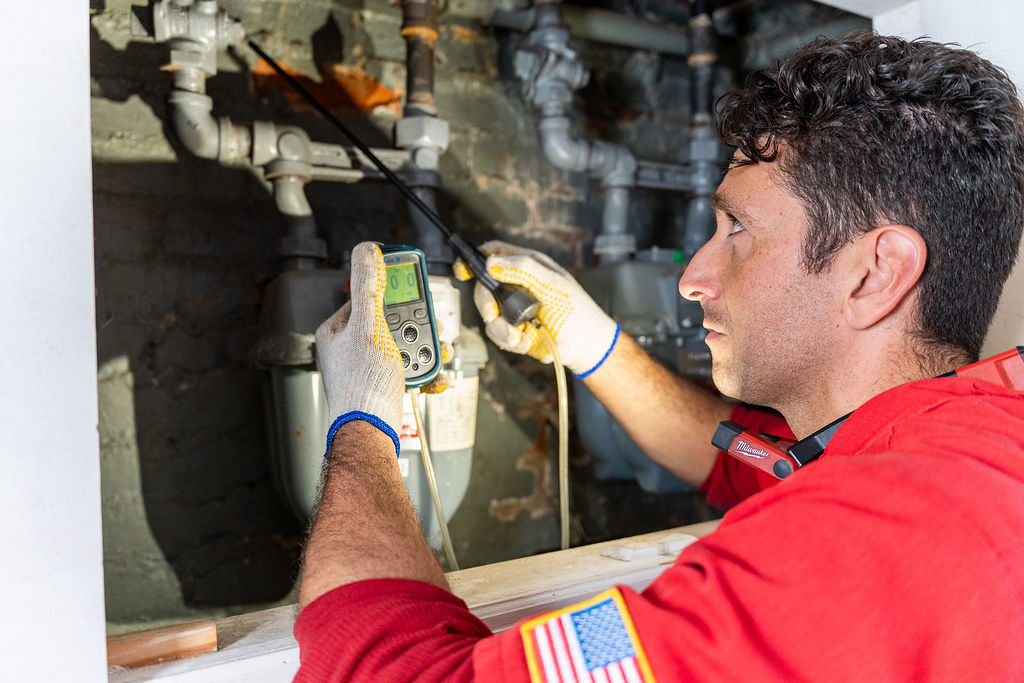Licensed technician performing a gas meter inspection using professional gas detection equipment
